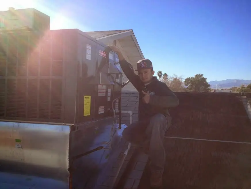 HVAC technician performing Air Duct Repair on a rooftop unit in Darby